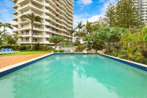 a swimming pool in front of a large apartment building at The Beachside - Fully Renovated 2BR unit with Parking Pool Tennis next to beach and tram in Gold Coast