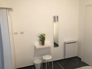 a white room with a potted plant and a mirror at San Bastian Rooms in Celle Ligure