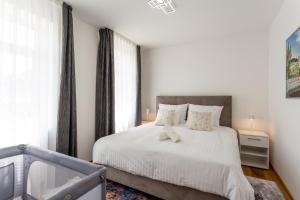 a bedroom with a white bed and a window at Vila Slovenka in Celje