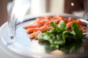 a plate of food with carrots and green lettuce at Seybolds Gästehaus in Lauffen am Neckar
