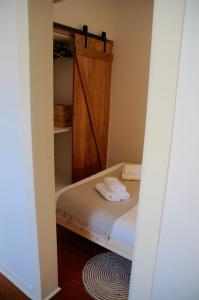 um pequeno quarto com uma cama e uma porta de madeira em Janela da Assembleia em Lisboa