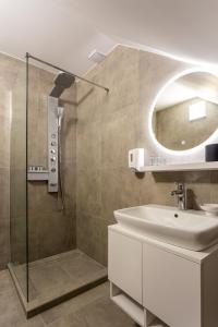 a bathroom with a shower and a sink and a mirror at Vila Slovenka in Celje +30 photos