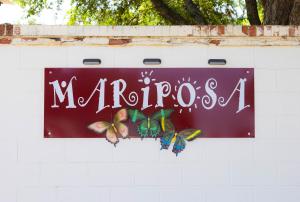a sign on a white wall with butterflies on it at Mariposa Buckeye - Retreat for 2 in Kerrville