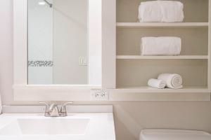 a bathroom with a sink and a toilet and towels at Seashell Shuffle at Sandestin Pilot House in Destin +54 photos