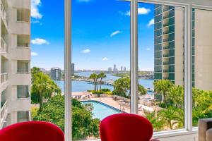 uma vista da água de um quarto de hotel com cadeiras vermelhas em Condo on the Pool - Retreat for 4 with Water Views & Resort-style Amenities em Miami mais 16 fotografias