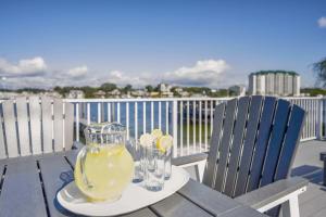 a table with a pitcher of lemonade and glasses on a balcony at Harbor Seahorse - Outdoor Deck & Boat Dock in Destin