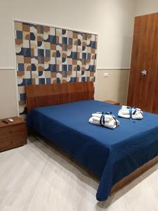 ein Schlafzimmer mit einem blauen Bett mit Handtüchern darauf in der Unterkunft Petit Maison in Castellammare di Stabia