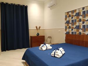 ein Schlafzimmer mit einem blauen Bett mit Handtüchern darauf in der Unterkunft Petit Maison in Castellammare di Stabia