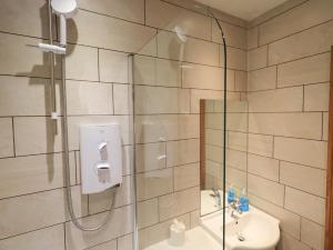 a bathroom with a shower with a toilet and a sink at Boxwood Cottage in Troutbeck +20 photos
