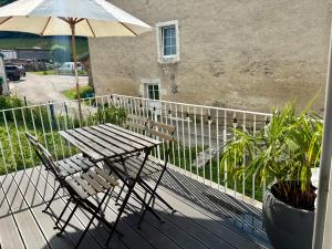 a table and chairs on a balcony with an umbrella at Appartement neuf 2 pièces 43m2 "Les Cimes" in La Chaux Neuve