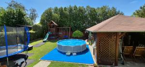 a backyard with a hot tub and a gazebo at Nagcsaládos Rózsa Apartman in Balatonlelle