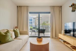 a living room with a couch and a tv at Sausalito | Pool View Retreat in Punta Cana