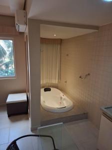 a bathroom with a tub in the corner of a room at Apartamento Suíte Flat Hot Springs Hotel em Caldas Novas com parque aquático in Caldas Novas +24 photos
