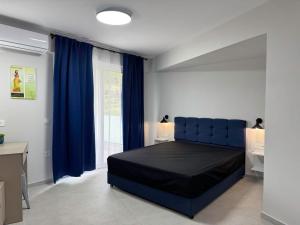 a bedroom with a blue bed and a window at 9muses luxury rooms in Vasiliki