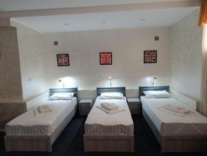 a room with three beds in a room at The Art Hotel by Art Hostel in Yakkasaray