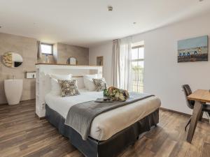 a bedroom with a large bed and a desk at Le Manoir de Kerbot in Sarzeau