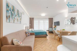 un salon avec un canapé et une chambre dans l'établissement SWAN Kołobrzeg Apartament KASPROWICZA 20C BASEN, SIŁOWNIA, BAWIALNIA - wszystko w cenie, à Kołobrzeg