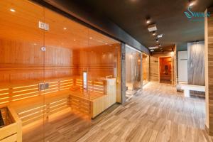 un sauna avec des boiseries et une paroi en verre dans l'établissement SWAN Kołobrzeg Apartament KASPROWICZA 20C BASEN, SIŁOWNIA, BAWIALNIA - wszystko w cenie, à Kołobrzeg