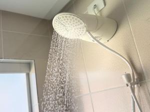 a shower with a shower head in a bathroom at Vale - Suítes Exclusivas (Bairro Nobre) in São Lourenço +39 photos