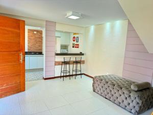 a living room with a bed and a kitchen at Vale - Suítes Exclusivas (Bairro Nobre) in São Lourenço