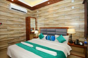 - une chambre dotée d'un grand lit avec des oreillers verts et bleus dans l'établissement A P Palace Hotel, à Ayodhya 8 autres photos