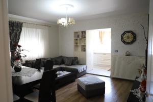 een woonkamer met een bank en een tafel bij Shtepi Pushimi Alesjo in Korçë +24 foto's
