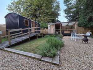 a tiny house in a yard with a table and chairs at Rustic 1BD Hut Retreat with Hot Tub & Countryside in Gedney +3 photos