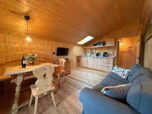 a living room with a couch and a table in a cabin at Langegger Alm - Sennerstube in Helmenstein