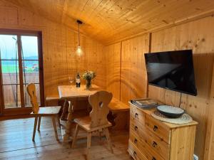 a dining room with a table and a television in a cabin at Langegger Alm - Sennerstube in Helmenstein