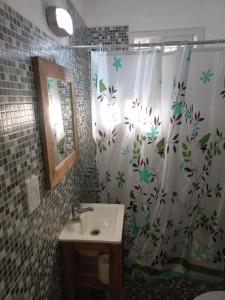 a bathroom with a shower curtain with a sink at Las Marias in Pilar