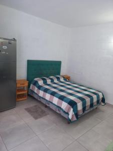 a bedroom with a bed with a checkered blanket at Las Marias in Pilar