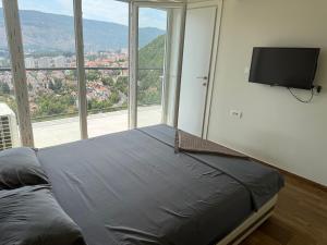 a bedroom with a bed and a flat screen tv at Herceg Novi Sunny Hill Apartment 