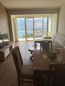 a living room with a couch and a table with chairs at Herceg Novi Sunny Hill Apartment 