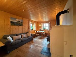 a living room with a couch and a table at Langegger Alm - Almhütte in Bernbeuren