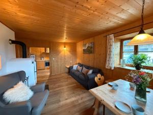 a living room with a couch and a table at Langegger Alm - Almhütte in Bernbeuren +24 photos