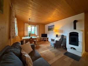 a living room with a couch and a wood stove at Langegger Alm - Almhütte in Bernbeuren