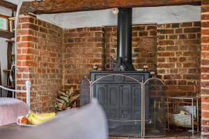 eine Backsteinwand mit einem Herd in einem Zimmer in der Unterkunft Two Bedroom Grade ll Cottage At AZ Luxury Stays Honey Horsefield With WiFi And Free Parking in Hundon