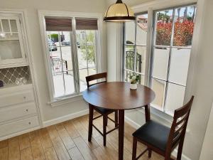 a dining room with a table and chairs and windows at Belmont Shore Beach House - Incredible Oceanfront Views in Long Beach