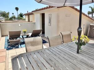 a table with chairs and an umbrella on a patio at Beauty by the Beach - SoCal Fun in Long Beach