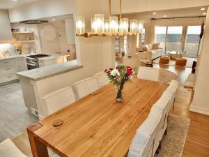 Una cocina y una sala de estar con una mesa y sillas de madera. en Beachfront Estate - LB Peninsula, en Long Beach