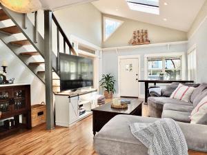 a living room with a couch and a staircase at Park Avenue Beach Paradise - Chic & Secluded 4 BDR in Long Beach