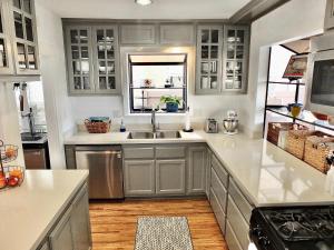 a kitchen with gray cabinets and a sink at Park Avenue Beach Paradise - Chic & Secluded 4 BDR in Long Beach