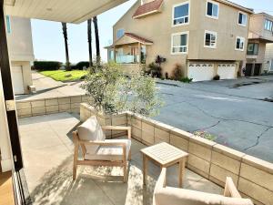 a patio with chairs and a table and a building at Beach Paradise - Stunning 3-Story in Long Beach in Long Beach +42 photos