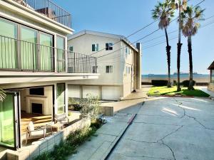 a large white building with a balcony and palm trees at Beach Paradise - Stunning 3-Story in Long Beach in Long Beach