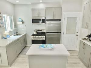 a kitchen with white cabinets and stainless steel appliances at Beach & Bay Retreat - Full of Amenities in Long Beach