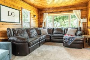 Una sala de estar con un sofá de cuero y una mesa. en Pet Friendly Lake Geneva Getaway for 6, en Lake Geneva