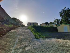 a dirt road with houses on the side at Kaz o ti plezi in Sainte-Rose