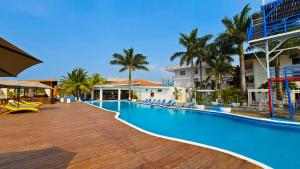 an empty swimming pool at a resort with palm trees at Hotel Partenon Beach in La Ceiba