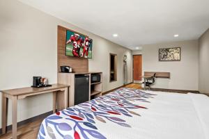 尤利斯Red Roof Inn & Suites Euless - DFW Airport Southwest的配有床和书桌的酒店房间