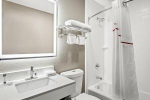 尤利斯Red Roof Inn & Suites Euless - DFW Airport Southwest的带水槽、马桶和镜子的浴室
